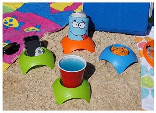 four beach coasters with cups, snacks, and a phone in each