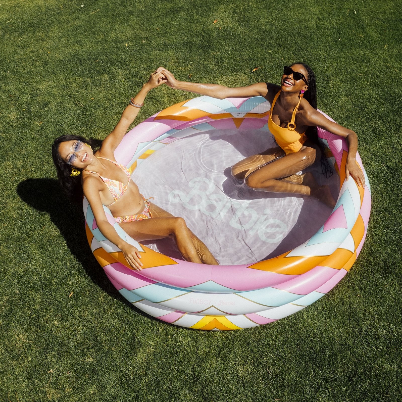 two adults in a barbie themed blow up pool