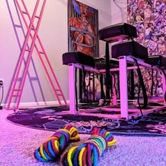 Pink bondage cross leaning against wall