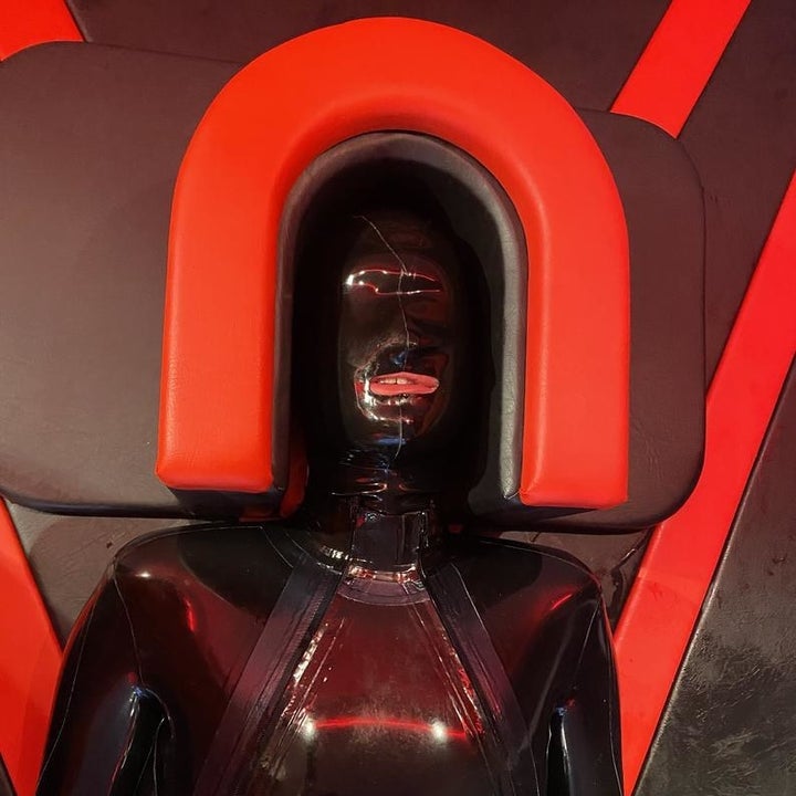 Model in latex laying in bottom of stool