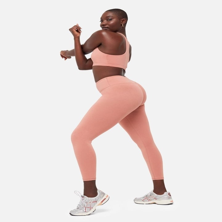 a model wearing the rose colored organic stretch leggings with matching sports bra