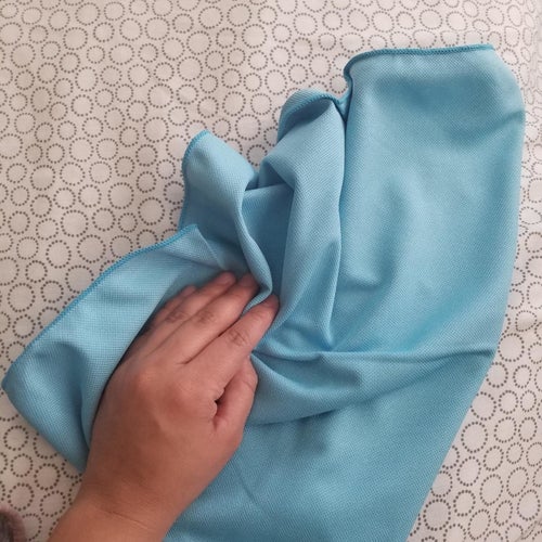 a reviewer wiping a surface with one of the cloths 