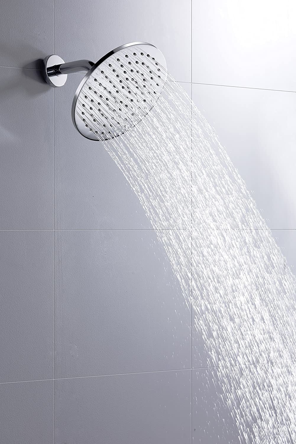 the polished chrome rain shower head spraying water in a shower