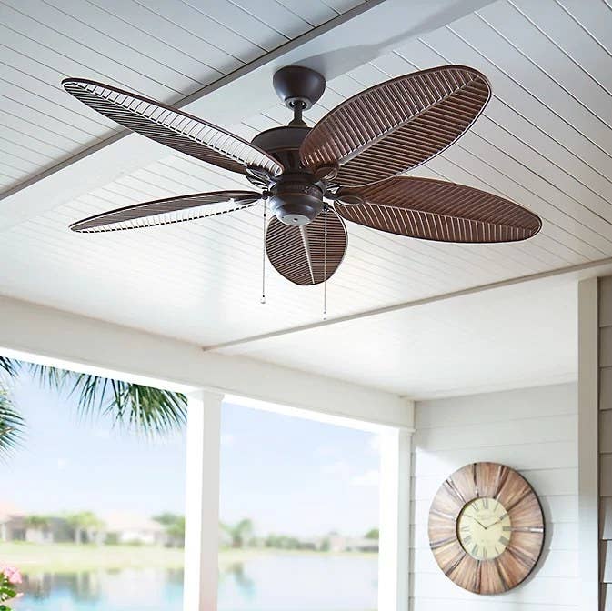 The brown fan hanging from a porch ceiling