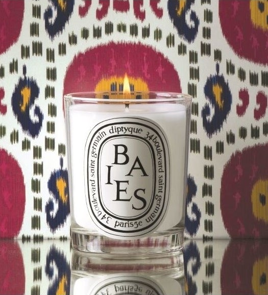 The candle in front of patterned wallpaper