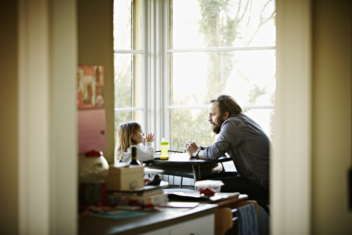 A father and daughter sitting at a table