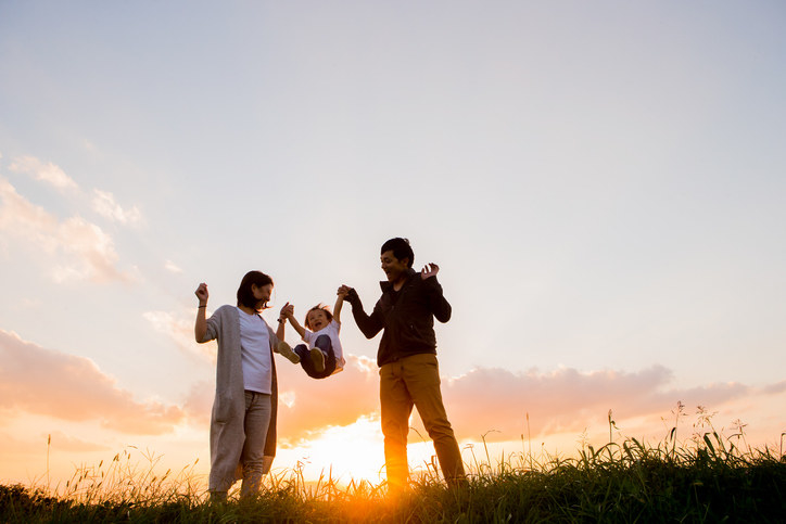 Parents swinging their child in the air