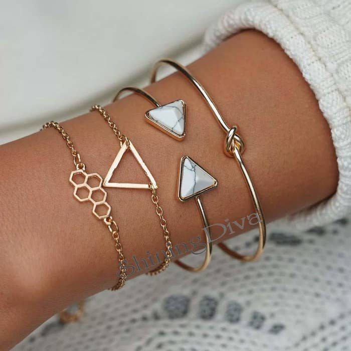 A multilayer charm bracelet on someone's wrist.