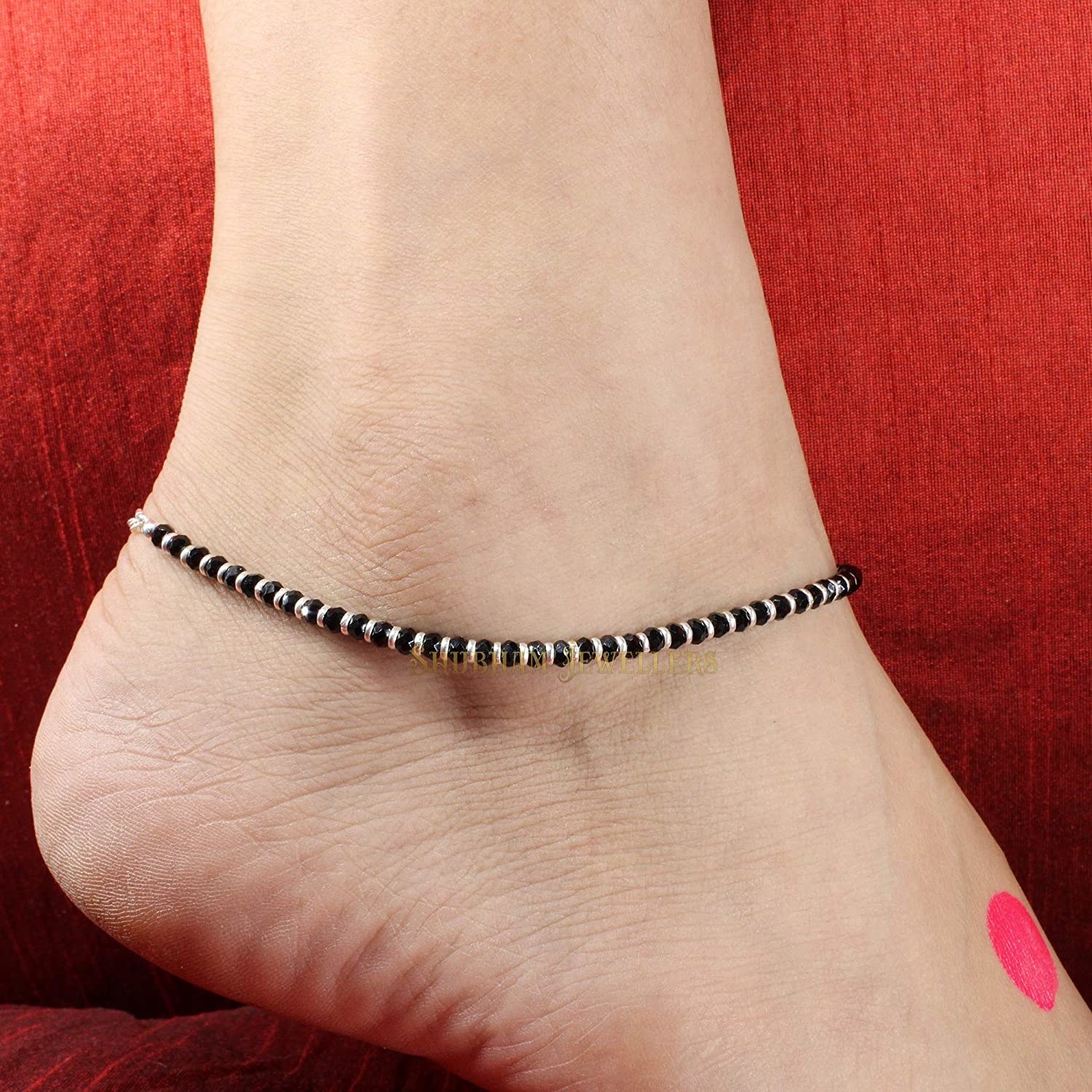 A sterling silver anklet on a woman&#x27;s ankle.