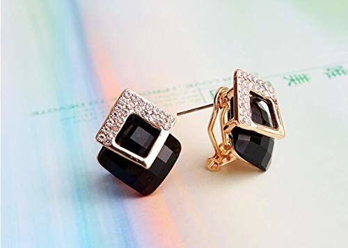A pair of black and gold earrings.