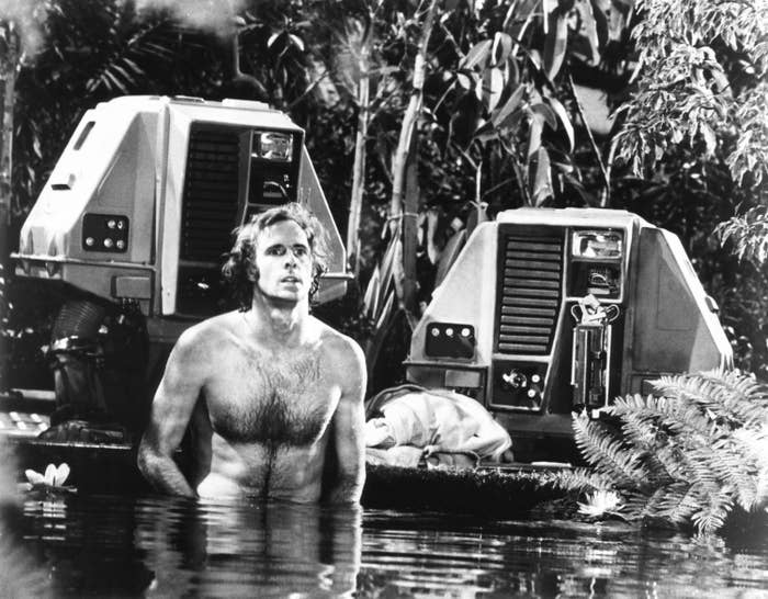 Bruce Dern walking through a lake near a space vehicle