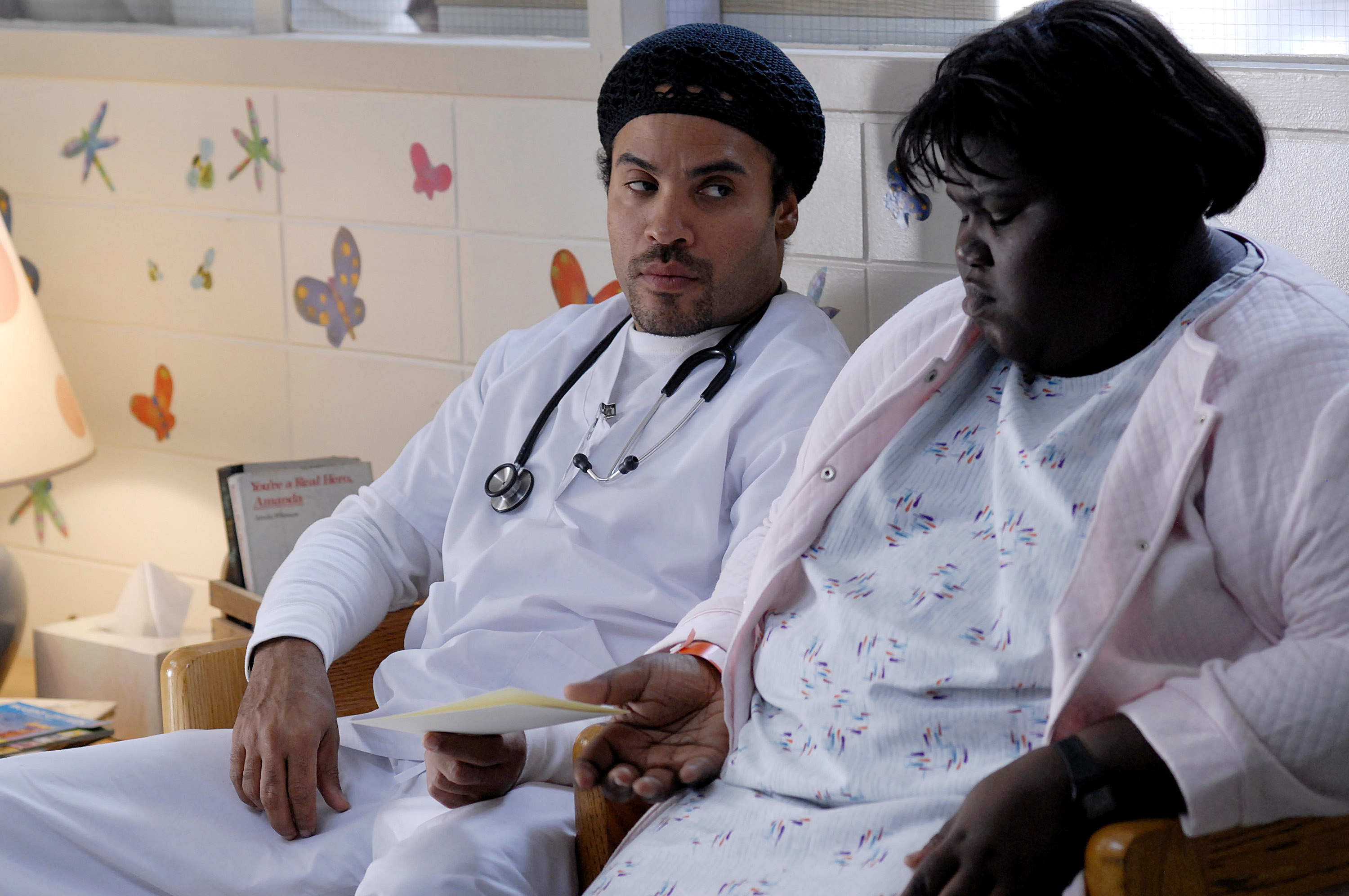 Lenny Kravitz in character as a doctor handing a paper to Gabourey &#x27;Gabby&#x27; Sidibe, who is also in character