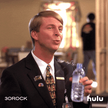 Kenneth the page on 30 Rock trying to drink from a bottle of water, but his hand is shaking, so it spills all over him