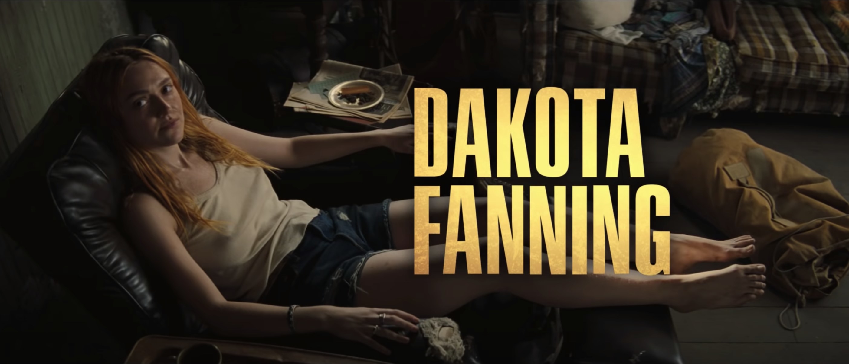 Dakota sits on a reclining chair in a screenshot from the movie