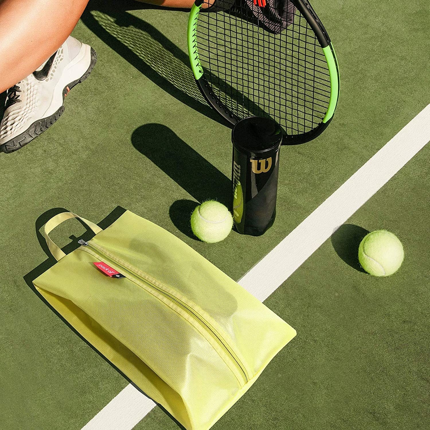 The bag next to a person holding tennis racket