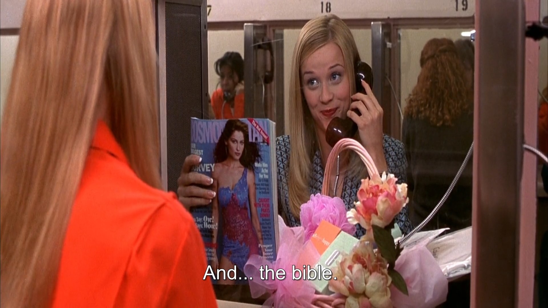 A blonde girl showing a Cosmopolitan magazine to a female prisoner