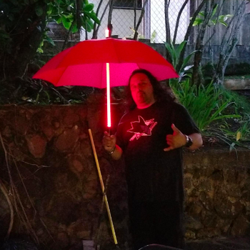 Different reviewer holding a red umbrella at night