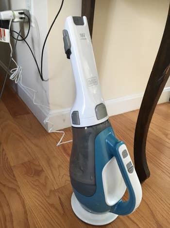 reviewer photo of the handheld vacuum charging upright plugged into an outlet
