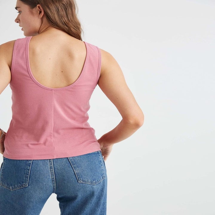 model wearing the tank in pink showing the scoop back