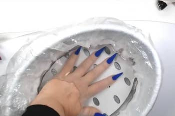 Reviewer placing their hand in the hot wax bath 