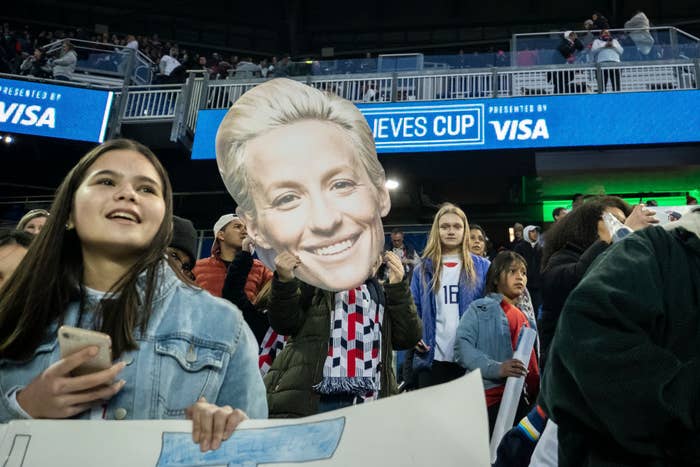 A fan holds a giant cutout of Megan Rapinoe&#x27;s face at the Shebelieves Cup