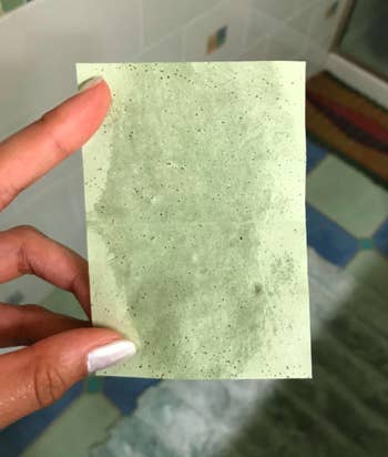 A customer review photo of them holding their used blotting paper