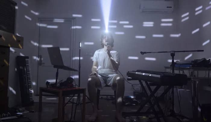 Bo Burnham wears a light on his head that illuminates around the darkened room as he sings &quot;Content&quot; in &quot;Inside&quot;