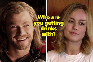 Thor looks up at someone as he smiles brightly and Carol Danvers narrows her eyes as she smiles.