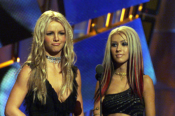Britney Spears and Christina Aguilera stand next to each other on stage at the MTV Video Music Awards in 2000