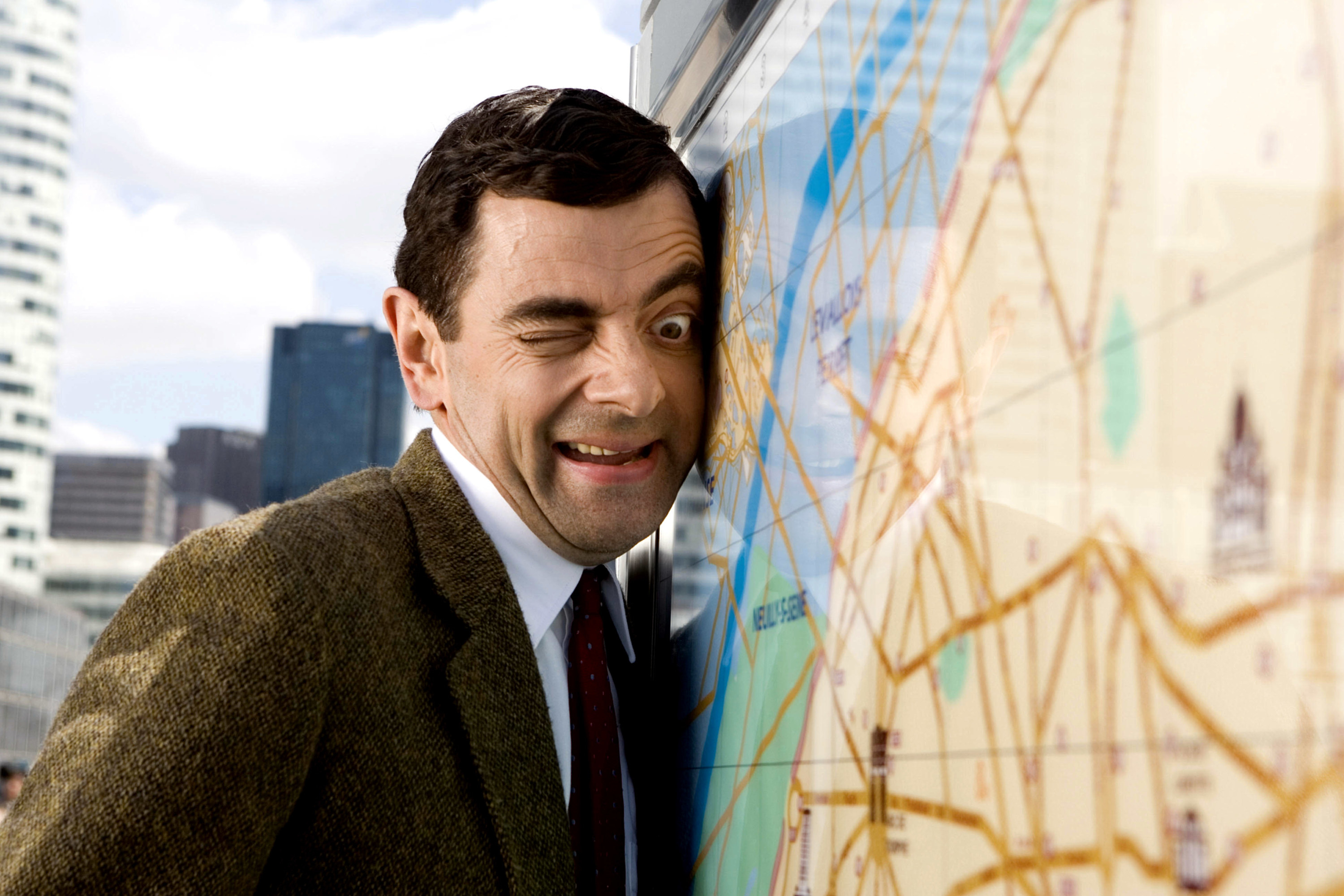 Mr. Bean with his face smushed against a map