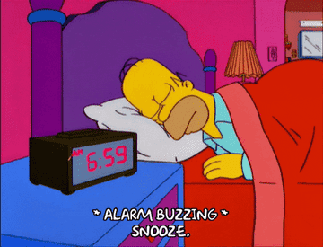 Homer Simpson hits his alarm clock&#x27;s snooze button and keeps sleeping