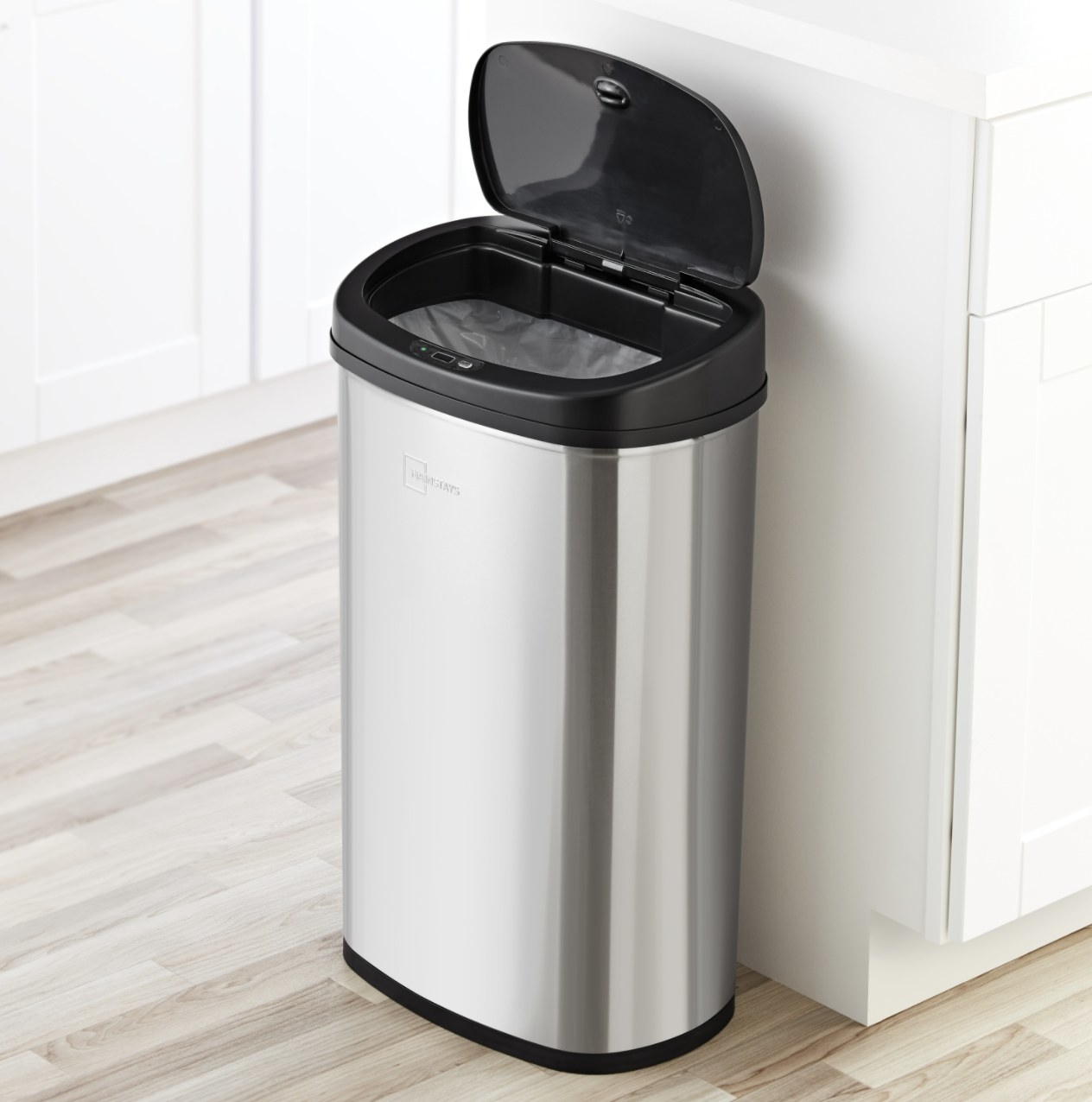 The silver trash can has the black lid in open position