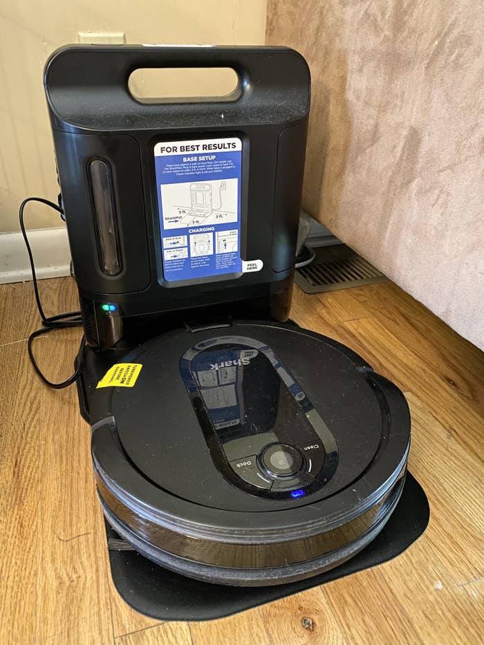 the circular, low-to-the-ground shark robot vacuum on it&#x27;s base