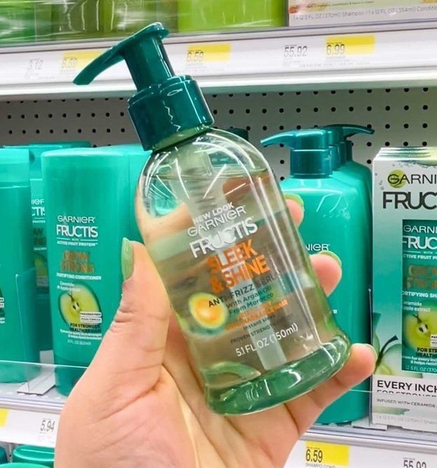 A person holding the bottle serum in a store aisle