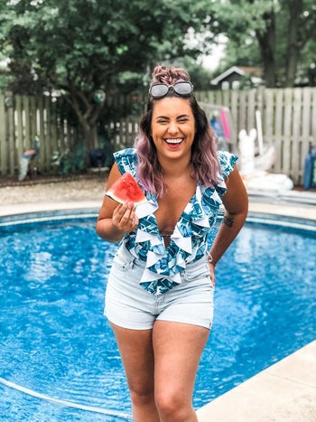 reviewer wearing the v-neck ruffle one-piece in blue and white pattern