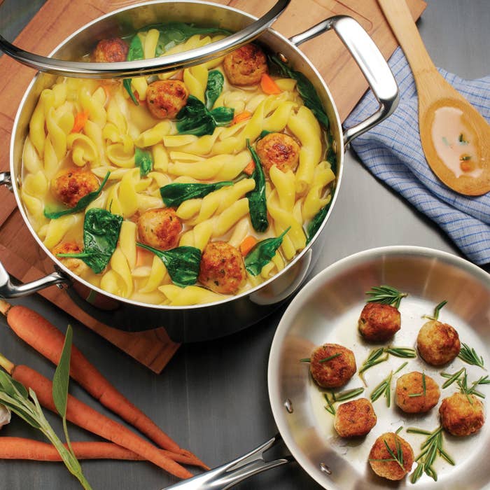 The cookware set cooking a pasta dish and scallops