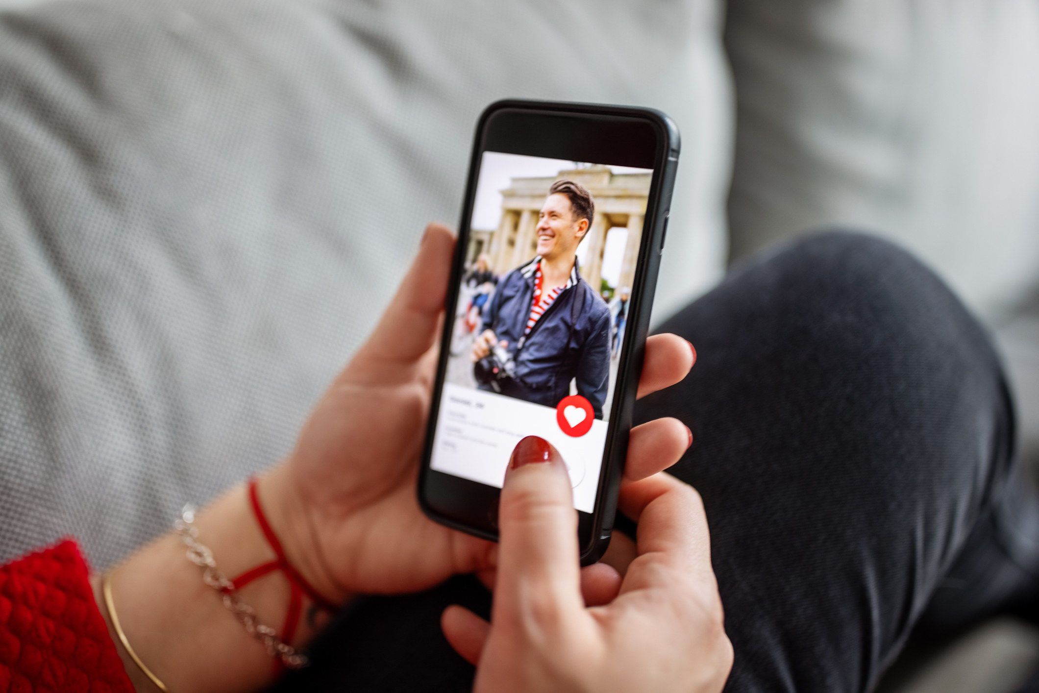 Woman looking at man on an online dating app on her mobile phone.