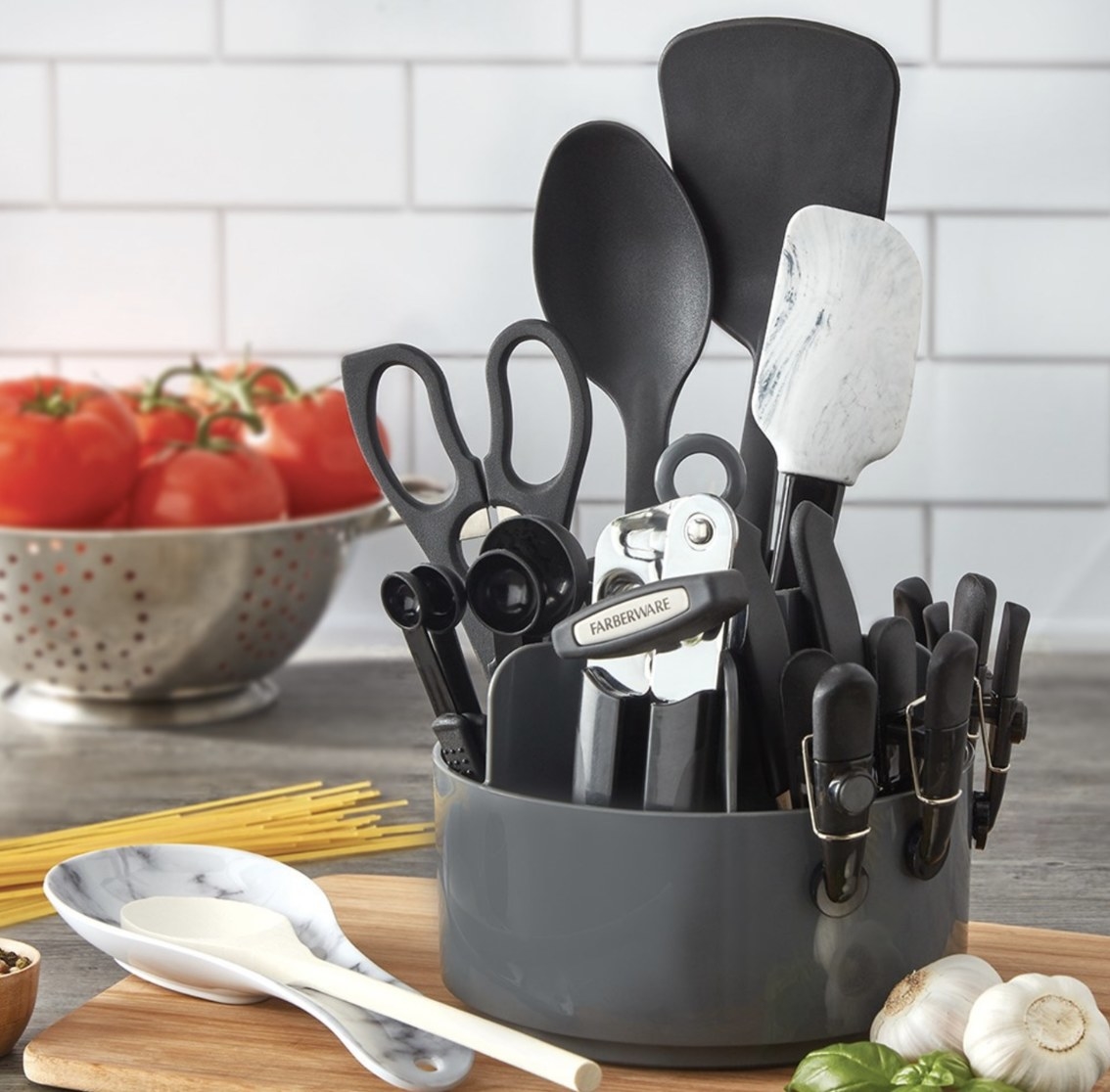 The black, stainless steel and marble set is on a countertop surrounded by pasta supplies