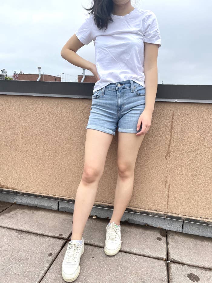 writer photo wearing the shorts and a white t-shirt standing on a roof