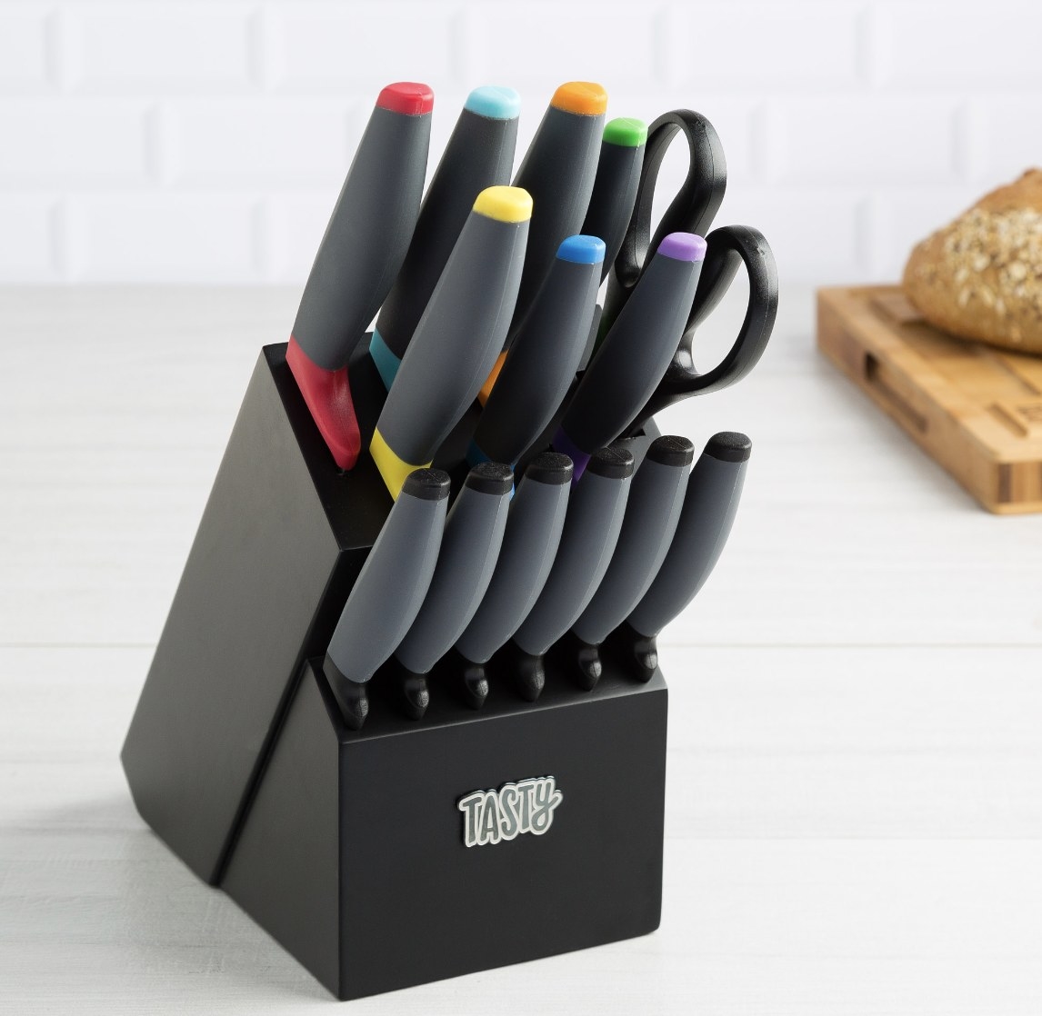 The black knife block says &quot;TASTY&quot;  and there are knifes with various colored handles