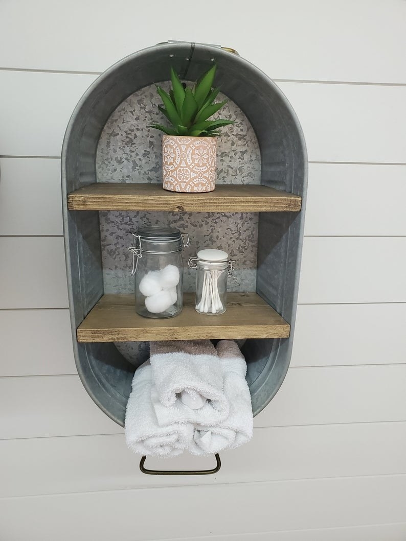 the galvanized wash tub with wooden shelves mounted on a wall with toiletries on each shelf