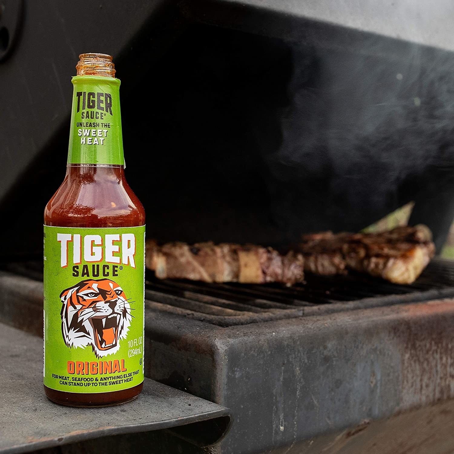 A bottle of Tiger Sauce next to a grill