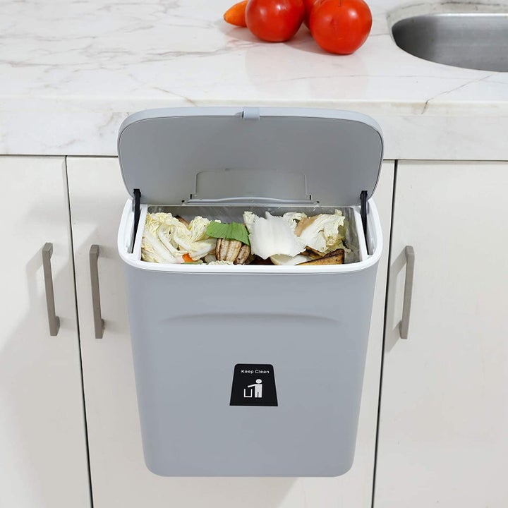 The holder clipped to a cabinet door, with the lid open