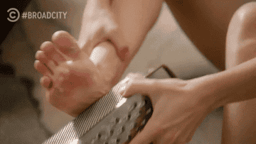 Ilana from Broad City using a cheese grater on her feet