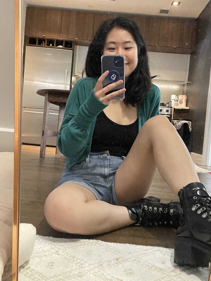 writer selfie wearing the shorts, combat boots, green cardigan