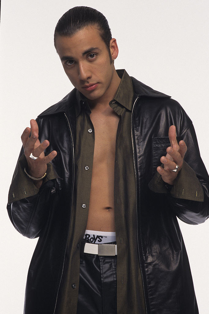 Howie D shirtless reaching out his hands