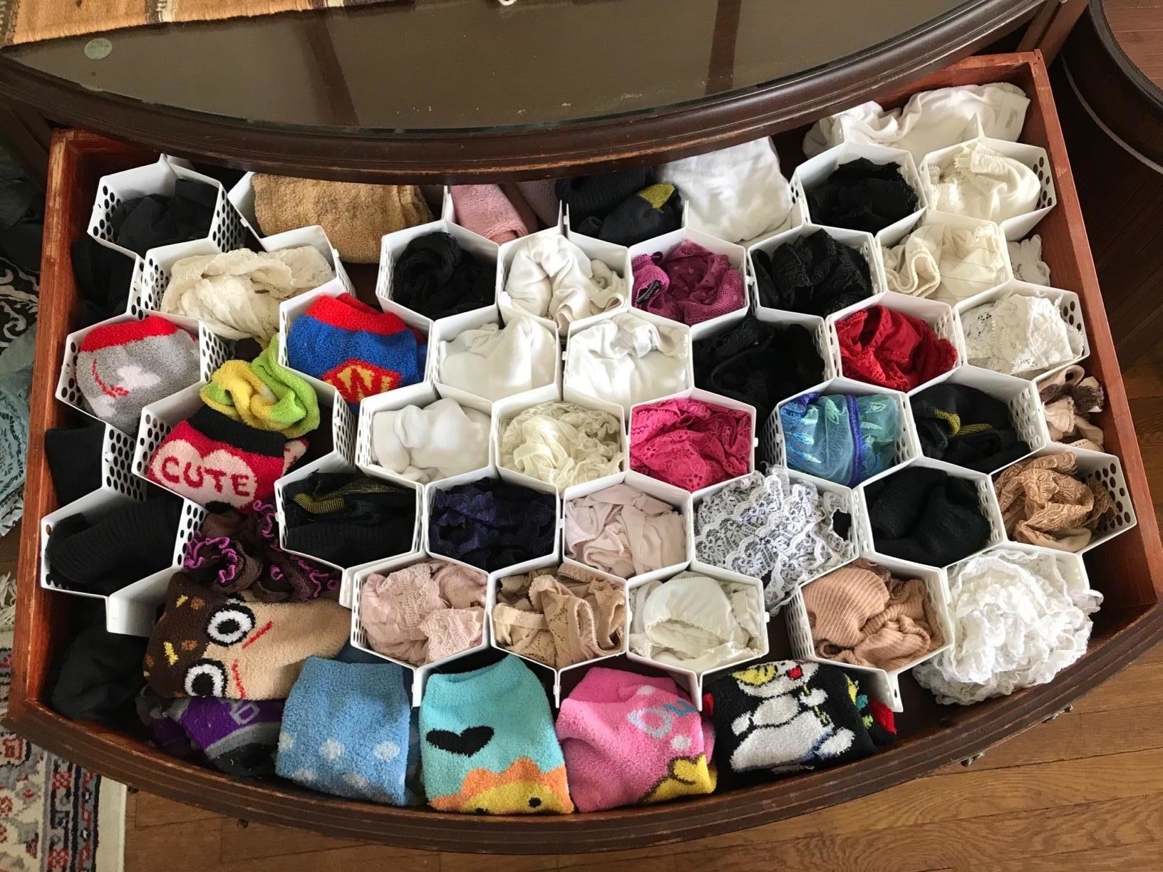 reviewer&#x27;s photo of a drawer with a honeycomb organizer placed inside to organize socks and underwear