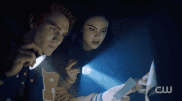 Archie and Veronica holding flashlights in Riverdale