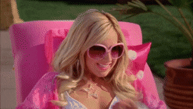 gif of Ashley Tisdale in the move &quot;High School Musical 2&quot; singing and dancing in a beach chair