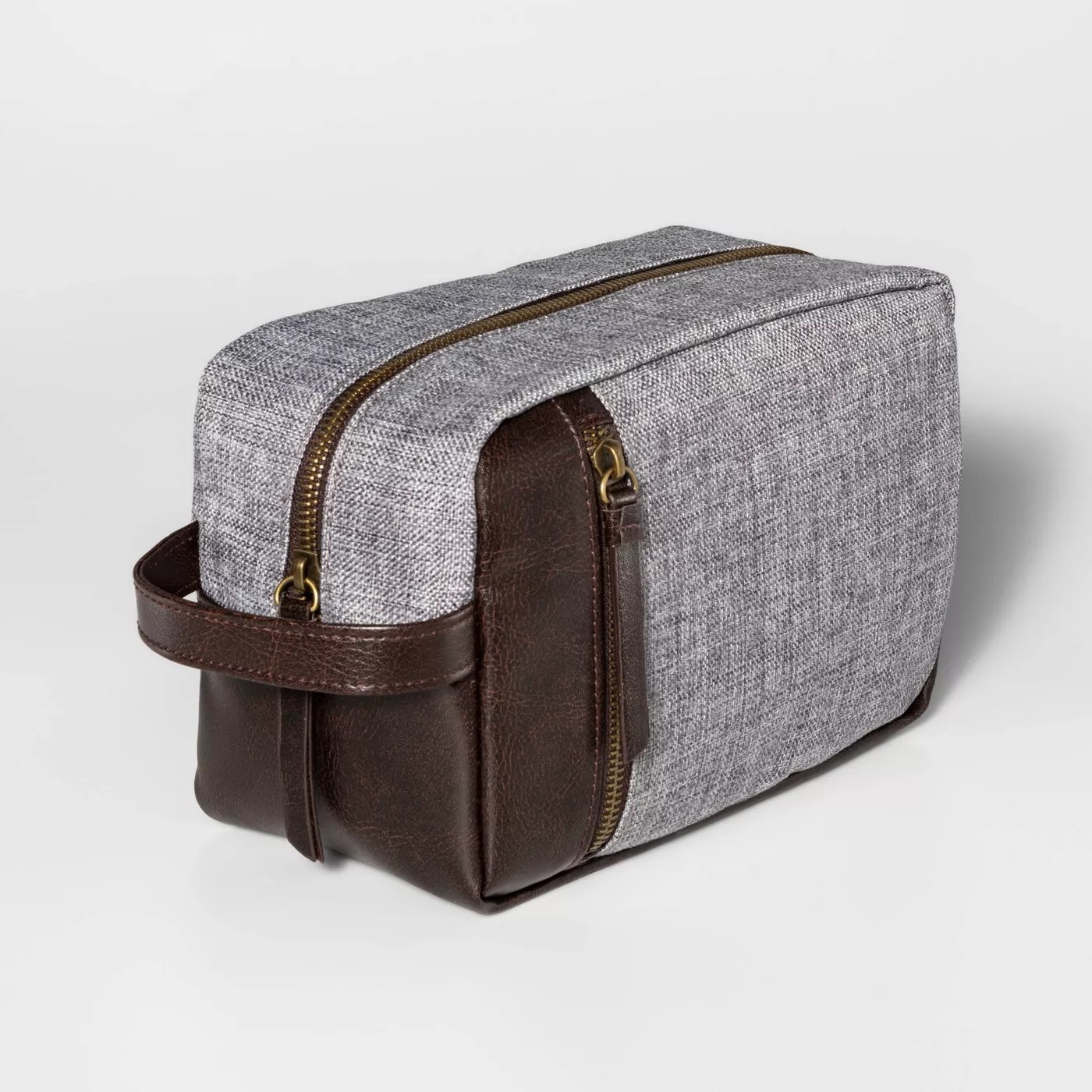 The dopp kit with a gray fabric exterior and brown leather accents